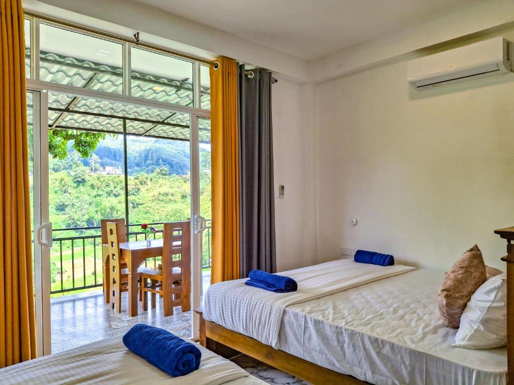 a bedroom with two beds and a balcony at Bees Honey Cottage Ella in Ella