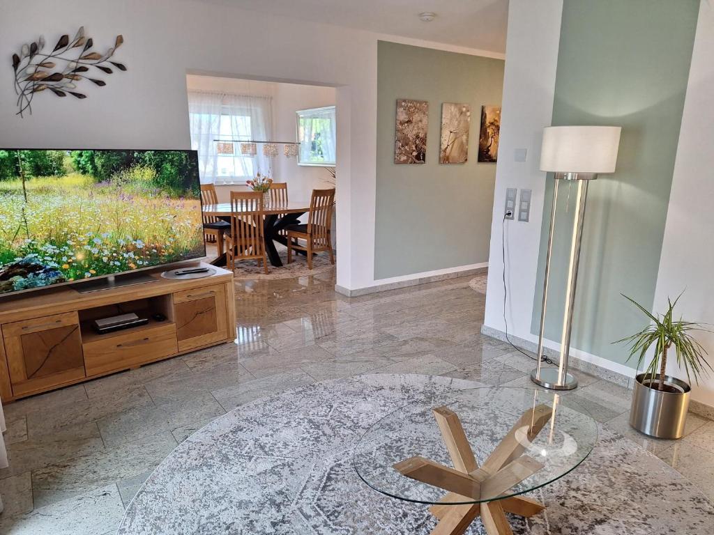 a living room with a television and a table at Modern & Gemütlich XL in Linden