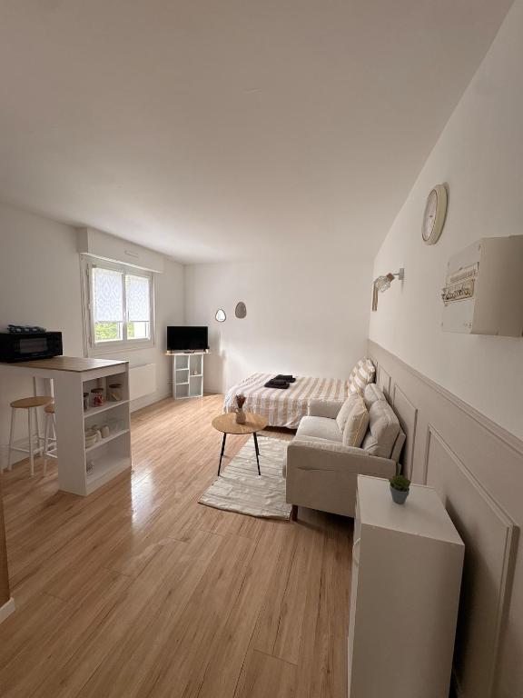 a white living room with a couch and a bed at Studio cosy & Lumineux parking privé in La Roche-sur-Yon