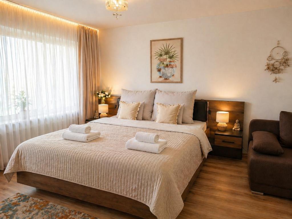 a bedroom with a large bed with two towels on it at Orient Apartmanház in Eger