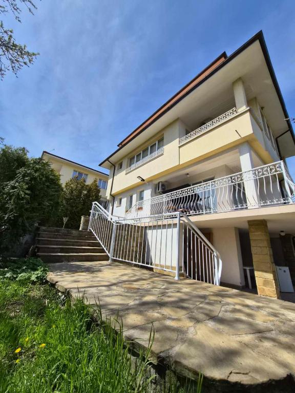 a building with a balcony and stairs in front of it at Blue Summer in Obzor