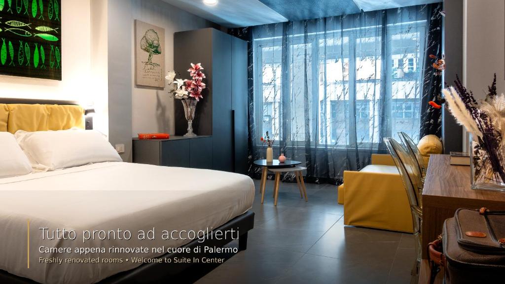 a bedroom with a bed and a table and a window at Suiteincenter Rooms in Palermo