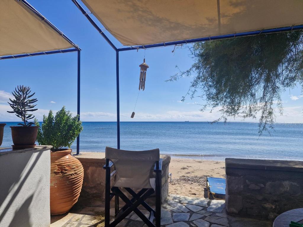 a view of the beach from a house with a chair at Thalias apartments in Kómi