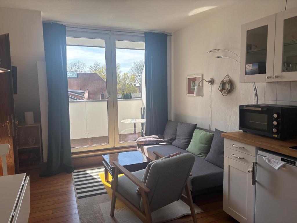 a living room with a couch and a table and a window at Kajüthus Apartment 2 in Fehmarn