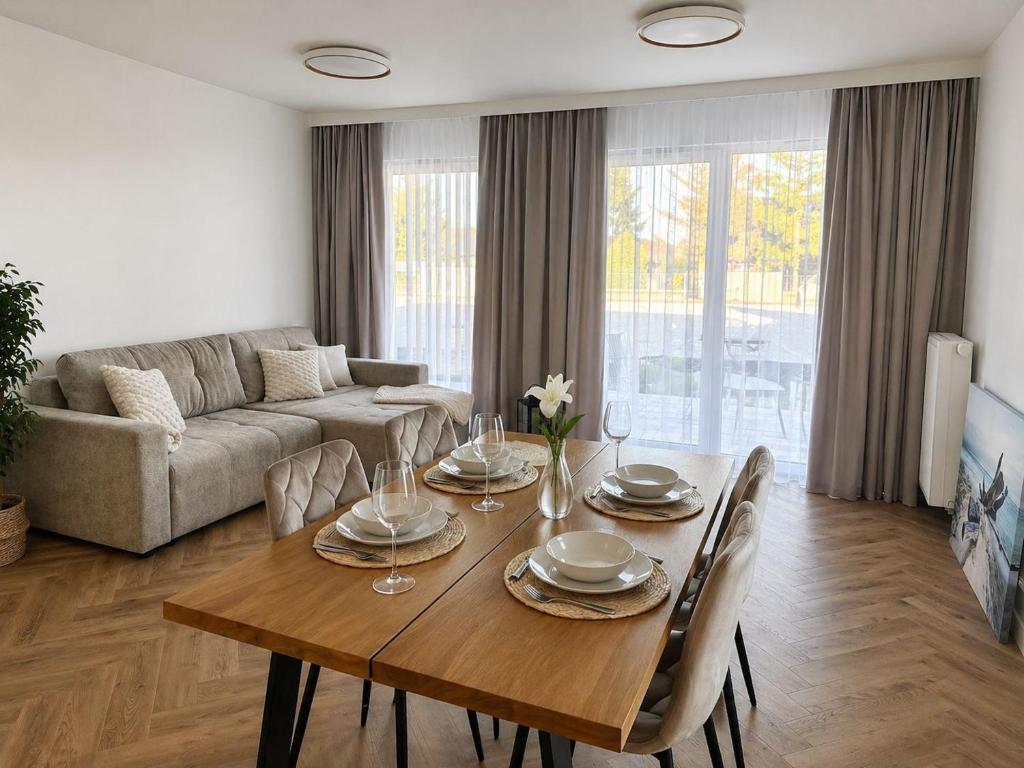 a living room with a wooden table and a couch at Pino SeaView I in Gdańsk