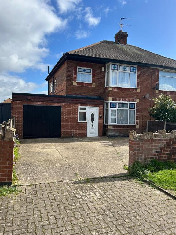 a brick house with a white door and a driveway at Rehoboth place in Nottingham