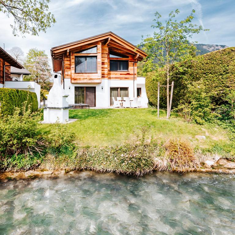 a house on a hill next to a river at Riverside Chalet Dreitorspitz in Garmisch-Partenkirchen