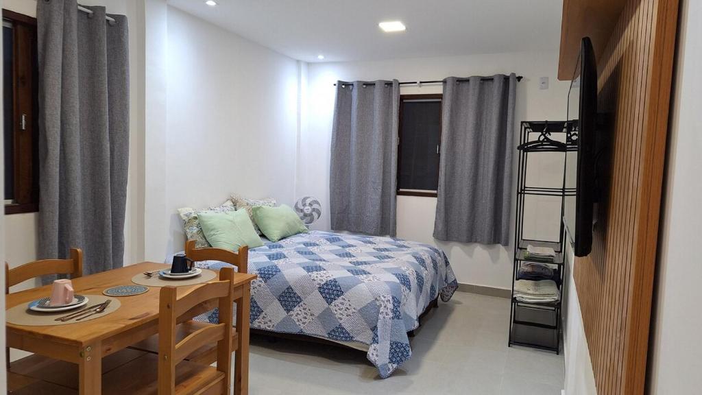 a small bedroom with a bed and a table and a desk at Studio prático e tranquilo em Jacobina in Jacobina