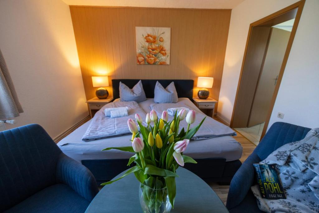 a bedroom with a bed and a vase of flowers on a table at Ferienpark Buntspecht in Pruchten