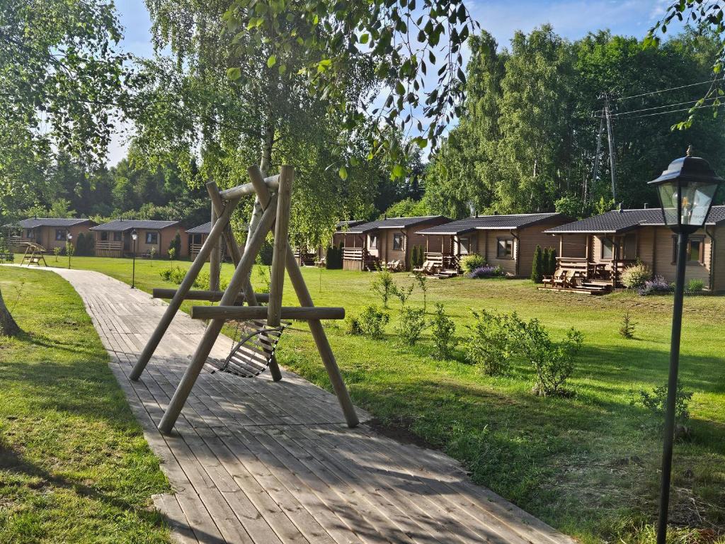 a swing set in a park with houses in the background at Domki PRZY LEŚNICZÓWCE in Wiele