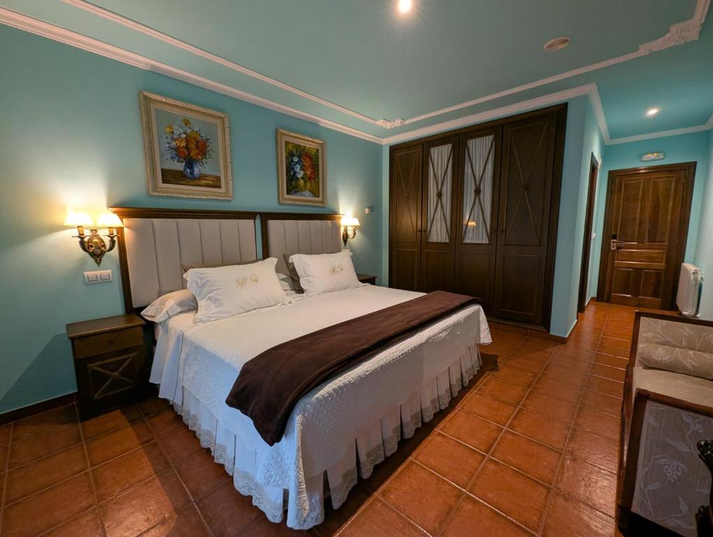 a bedroom with a large bed with blue walls at Hotel Boutique El Pescador in Cudillero