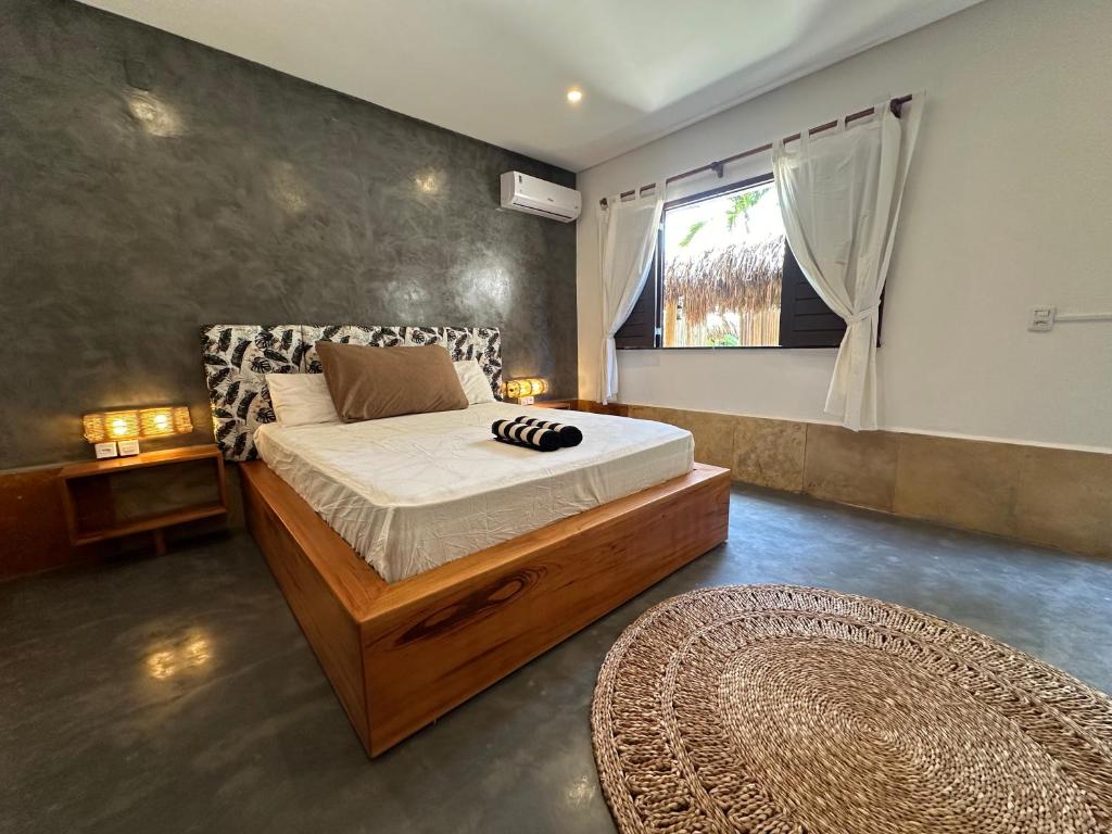 a bedroom with a bed and a window and a rug at Oasis Tropical in Paracuru