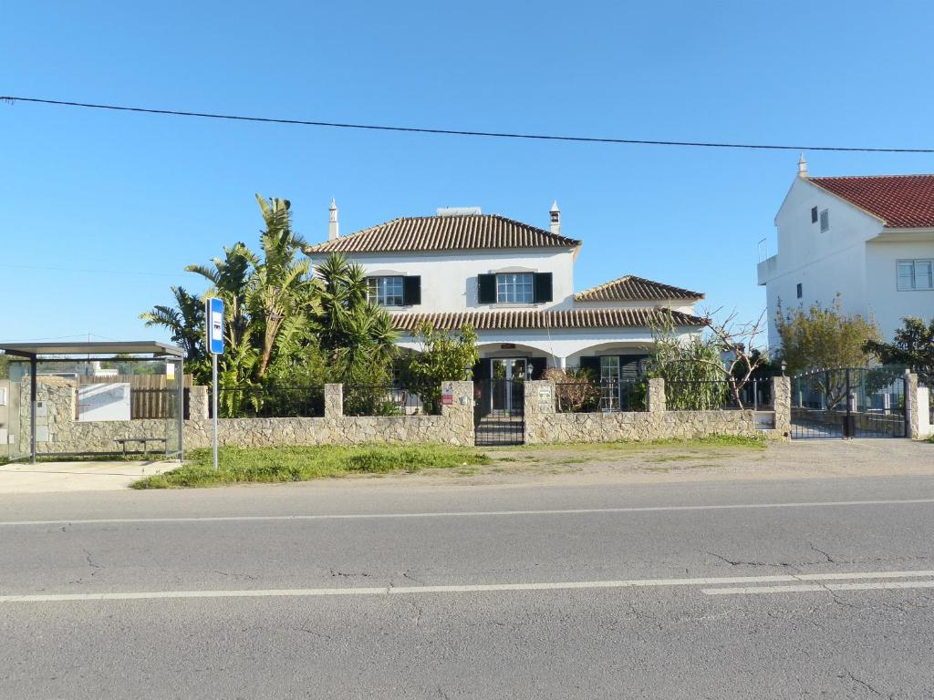 a house on the side of a street with a fence at Sandra B&B in Luz de Tavira