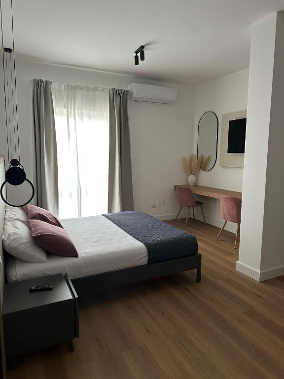 ein Schlafzimmer mit Bett, Schreibtisch und Fenster in der Unterkunft Domus Ale in Vallo della Lucania