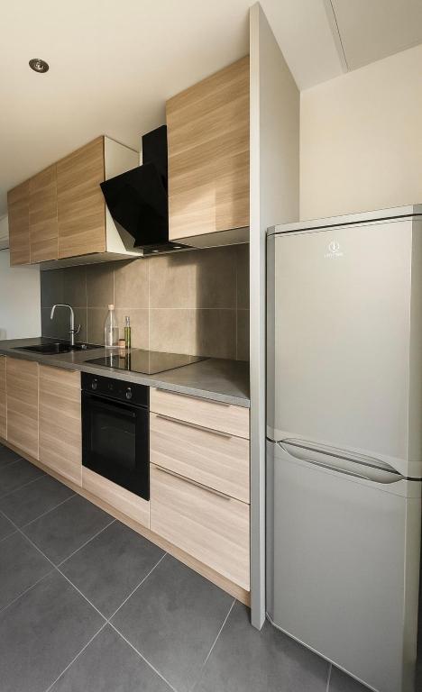 a kitchen with wooden cabinets and a refrigerator at Les vacances in Sainte-Maxime