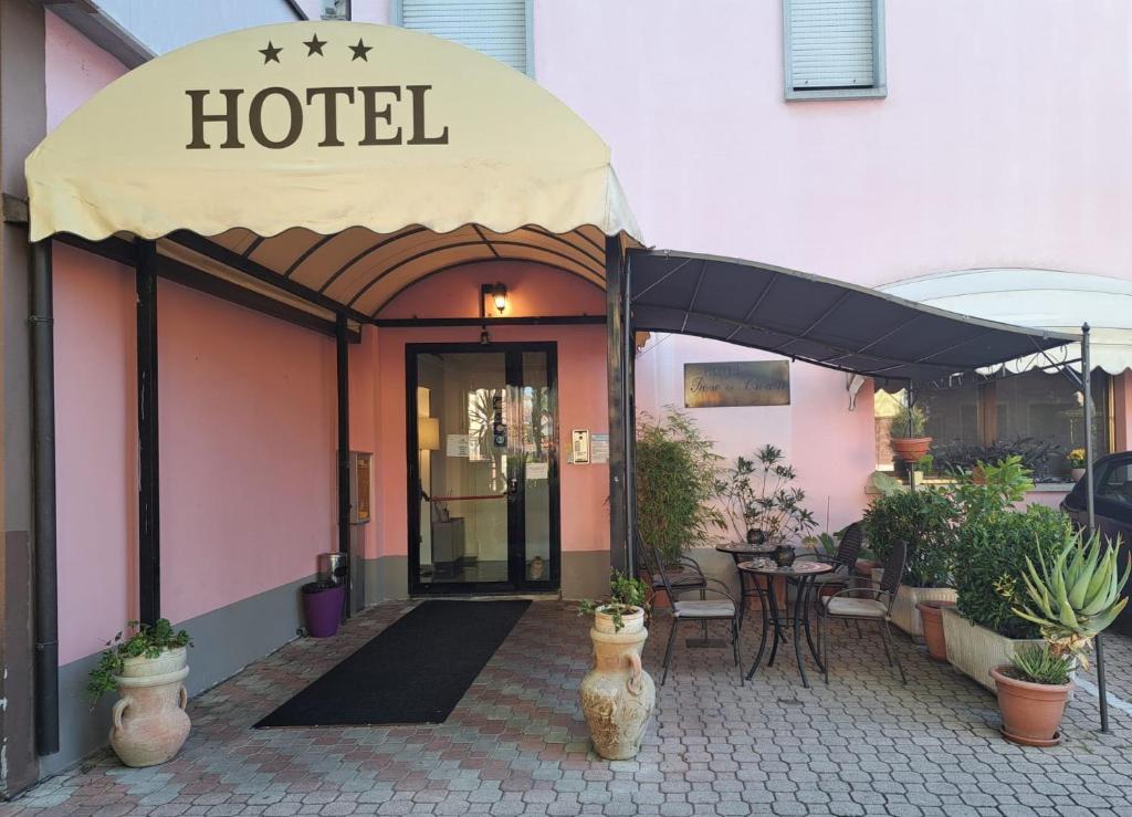 a hotel with an awning in front of a building at Hotel Rose&Crown in Correggio