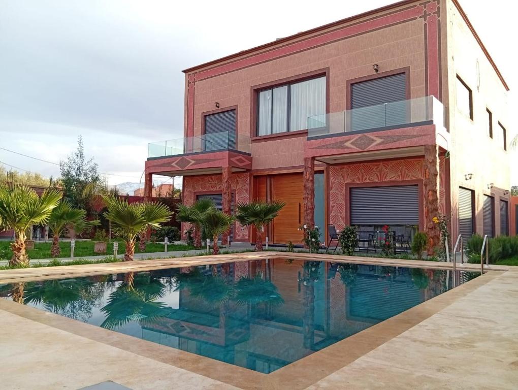 a house with a swimming pool in front of a building at Villa Golden Sun in El Jemʼa Ghemat