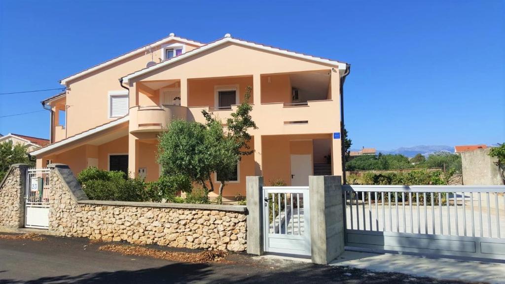 a house with a gate and a fence at Apartmani FILTEA in Vrsi