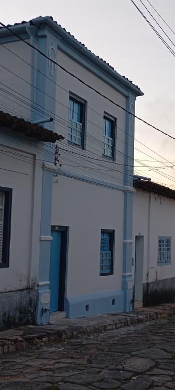a white building with a blue door and windows at Casarão D'Ávila aluguel por temporada in Goiás