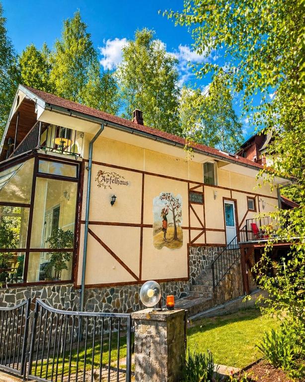 a house with a fence in front of it at Apfelhaus Poiana Marului in Poiana Mărului