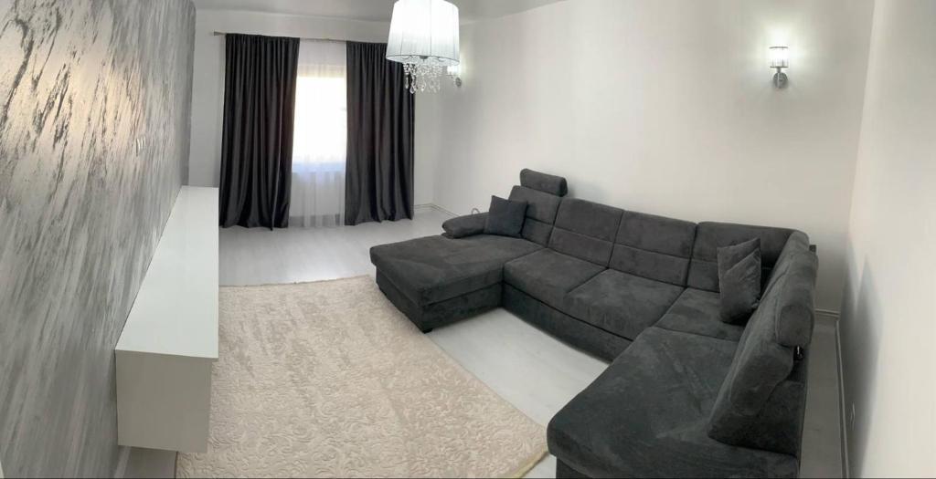 a living room with a gray couch and a table at Apartament ICAS 2 in Dej