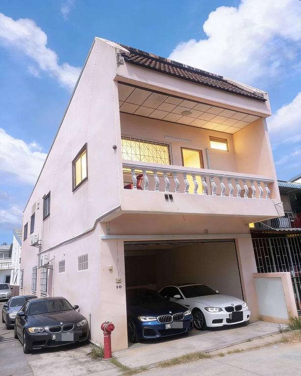 a house with two cars parked in a garage at hatyai homestay greenway orkar in Hat Yai