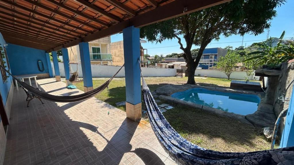 a patio with a hammock and a swimming pool at Casa com Piscina Privativa e Churrasqueira in Araruama
