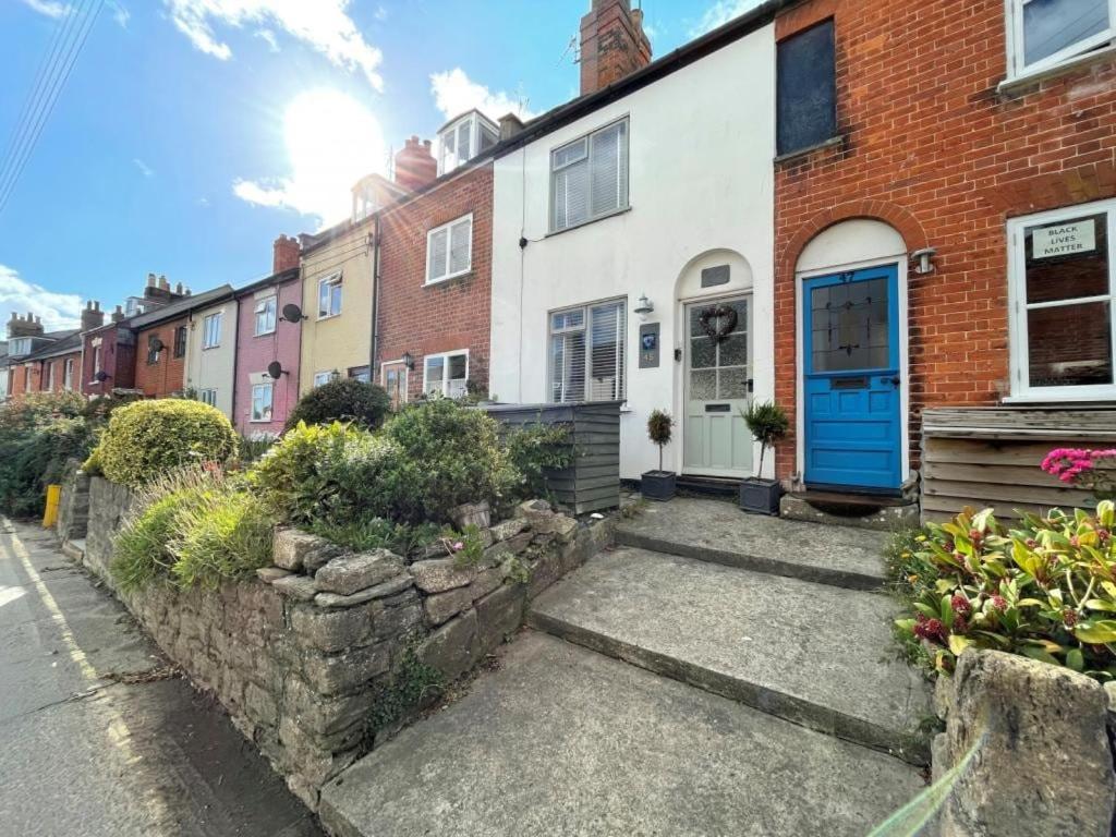 a house with a blue door on a street at Oligrae Cottage in Bridport