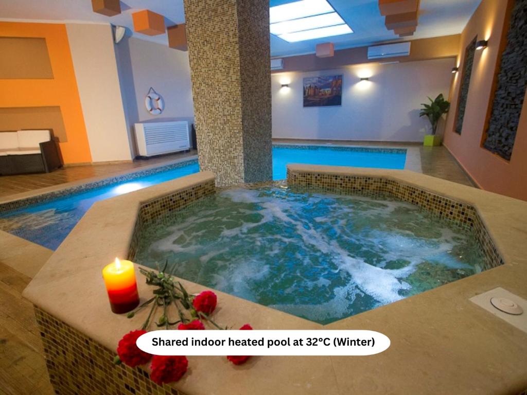 a hot tub in a hotel room with a candle at Belle Apartments in St. Julianʼs
