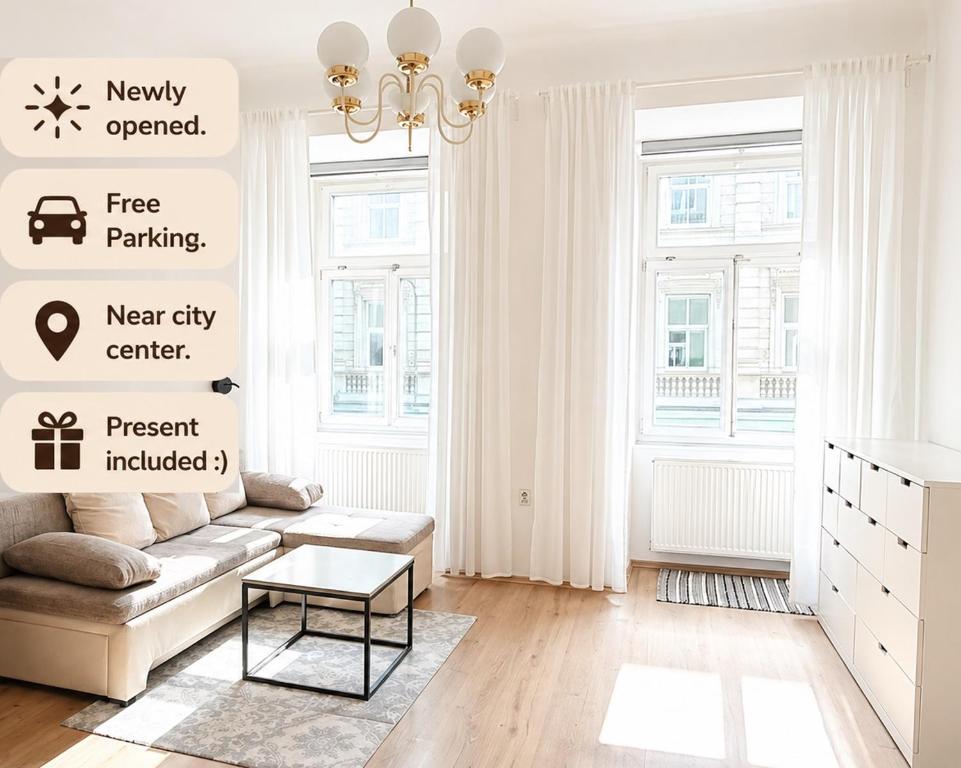 a white living room with a couch and a table at City Center Apartment in Brno