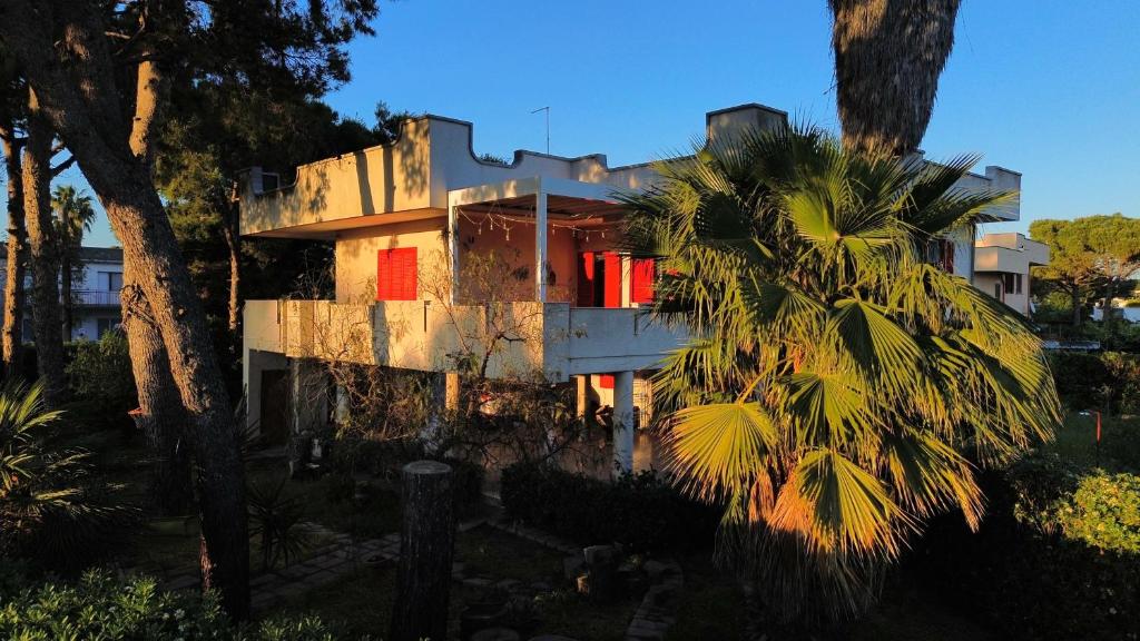 a house with red doors and a palm tree at WalMarhouse in Taranto