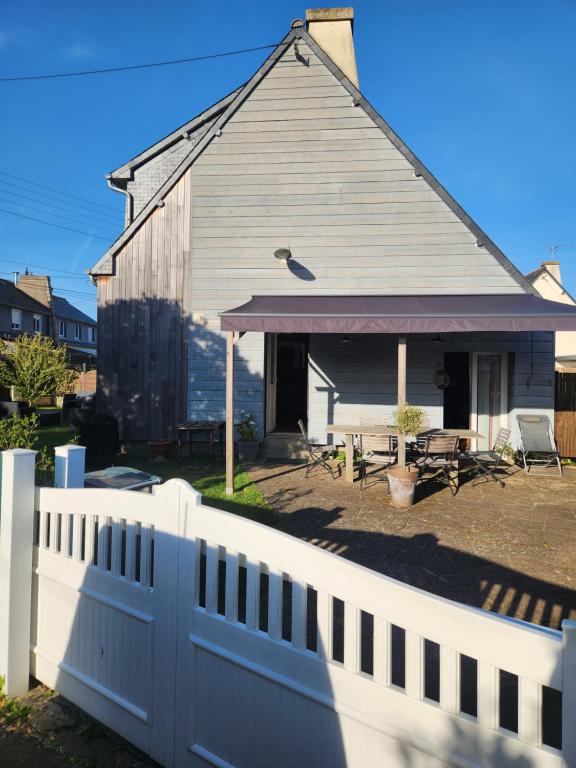 a white fence in front of a house at Charmante maison in Dinard