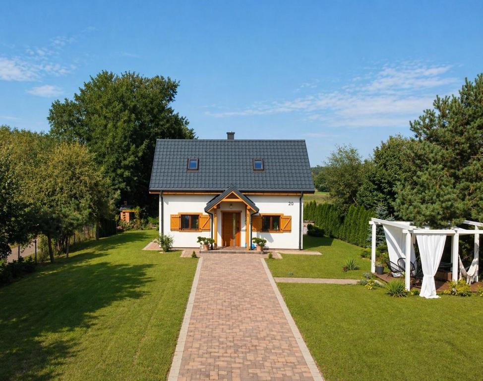 a small white house with a brick driveway at Nadbużańska Ostoja in Kamieńczyk