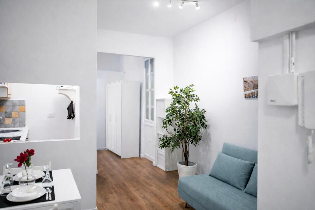a living room with a blue couch and a plant at Le Erbe Apartment tra Locali e vita Universitaria in Genoa
