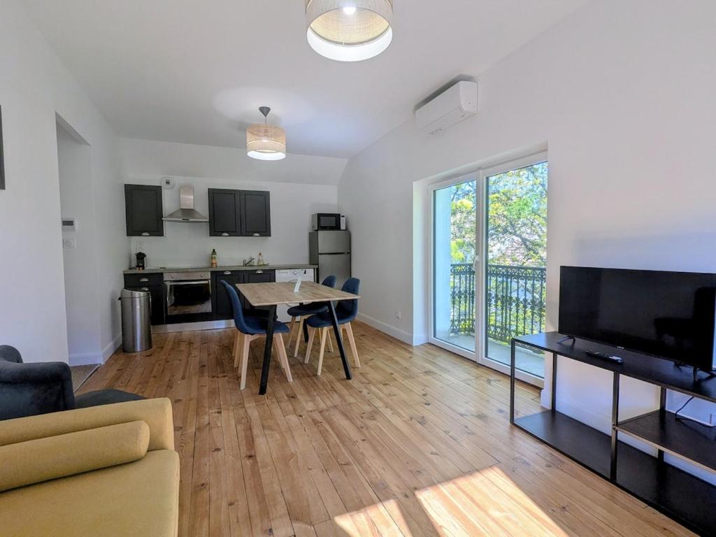 a living room with a table and a kitchen at Two-bedroom apartment with air conditioning in Vichy