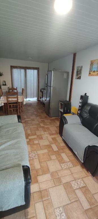 a room with two beds and a couch and a kitchen at Cabaña Dos Pinos in Durazno