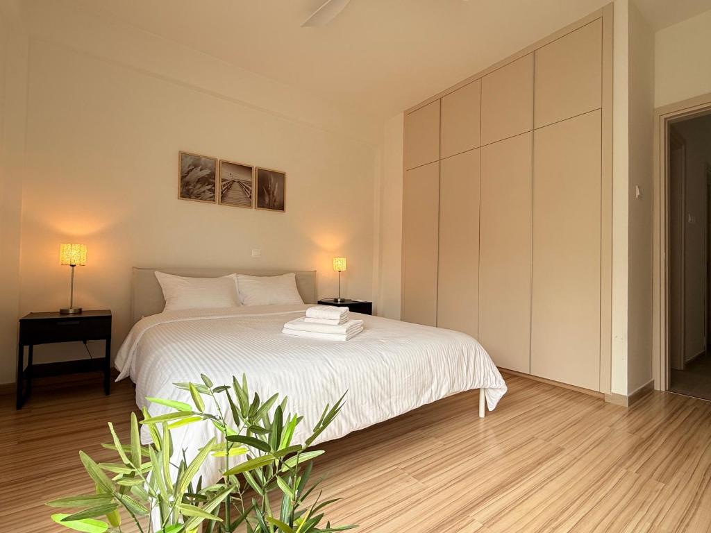 a bedroom with a white bed and a plant at Nicosia Neoclassic Retreat in Nicosia