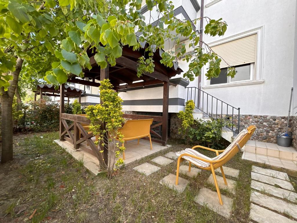 a picnic table and a bench in front of a house at Small Garden House in Draç