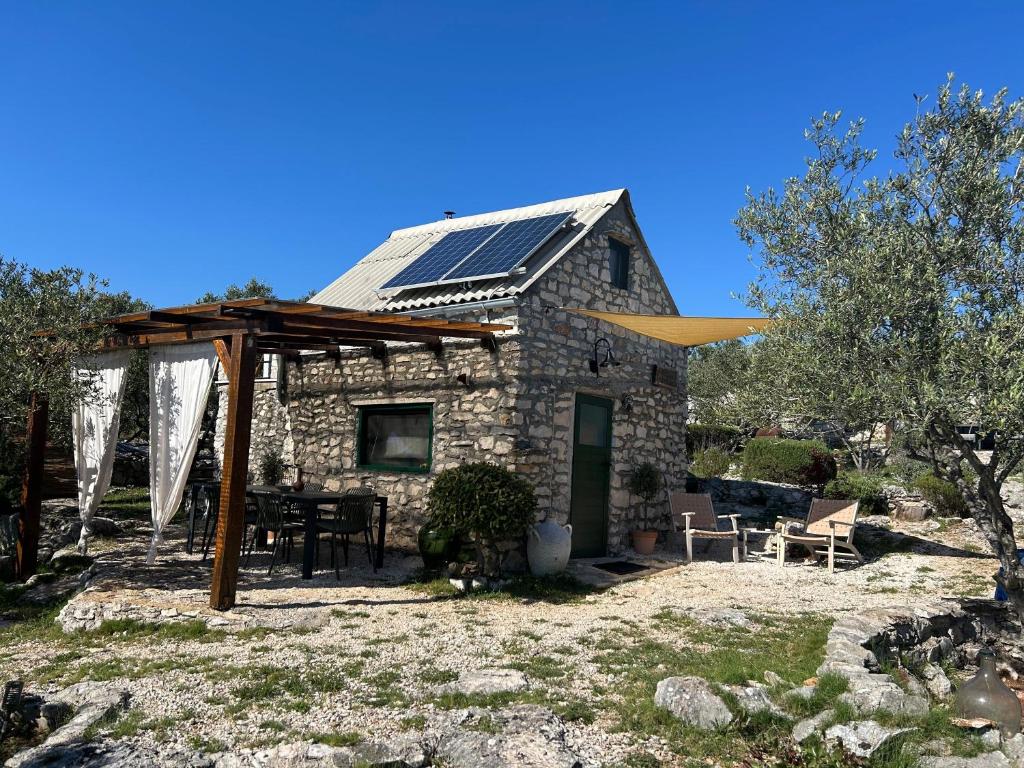 a stone house with solar panels on the roof at Mrdina house in Kali