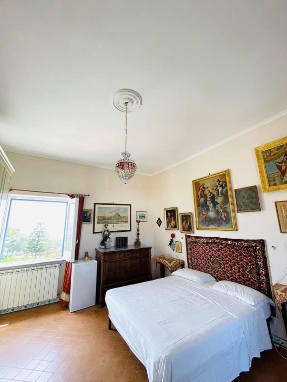 a bedroom with a white bed and a window at Maison Artista in Procida