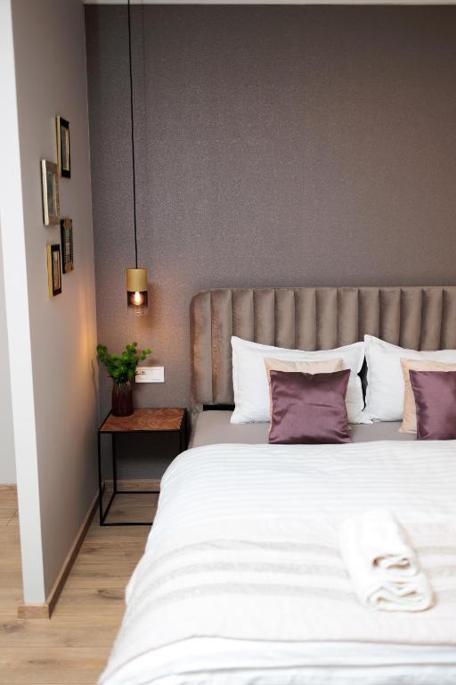 a bedroom with a large white bed with purple pillows at KB House apartman in Malý Horeš