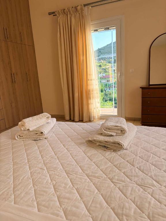 a bedroom with a large bed with two towels on it at Dimitris House in Pllakë