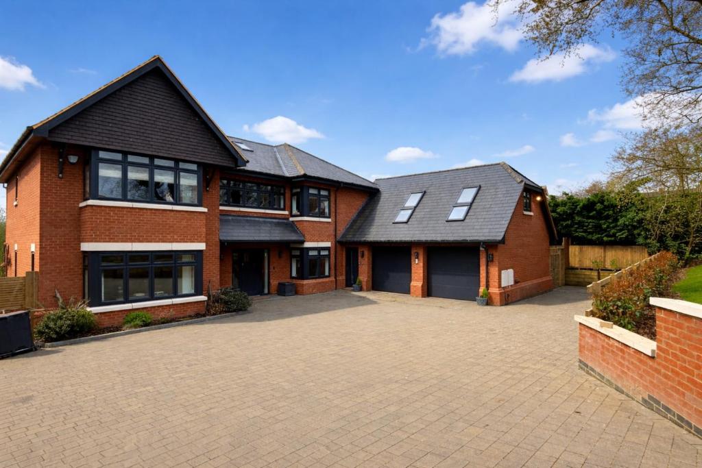 a brick house with a driveway in front of it at THE STUDIO - Silverstone village - walking distance to track in Silverstone