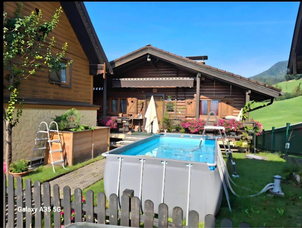 a house with a swimming pool in the yard at Romantikhäuschen zum Dachsteinblick in Abtenau