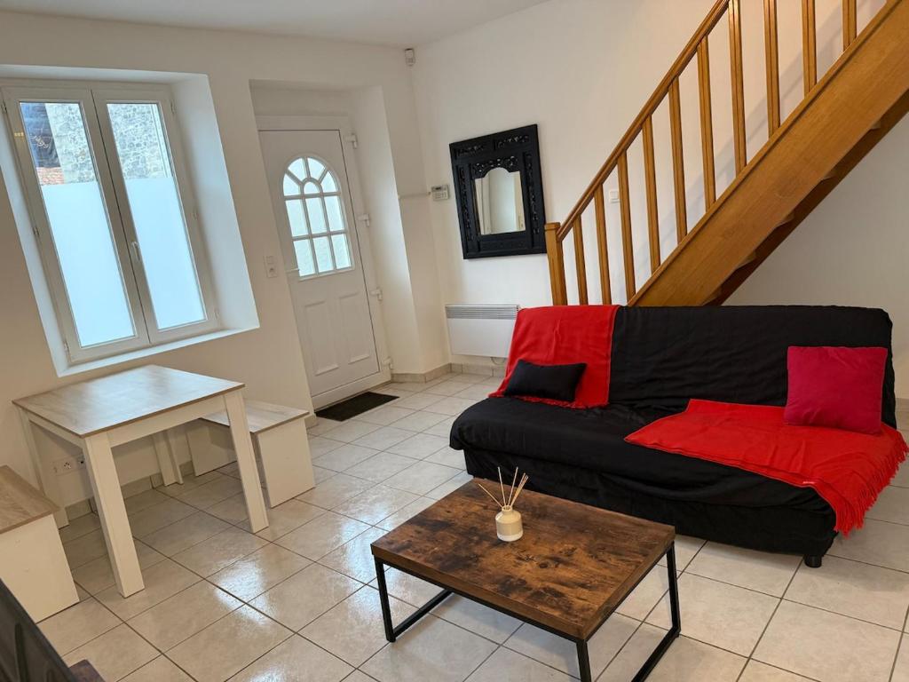 a living room with a black couch and a table at Maisonnette du Prieuré in Saint-Gilles