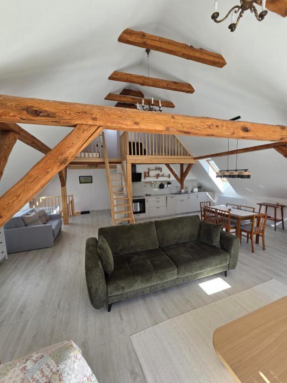 a living room with a couch and a dining room at Apartament Pod Orzechem in Ulinia
