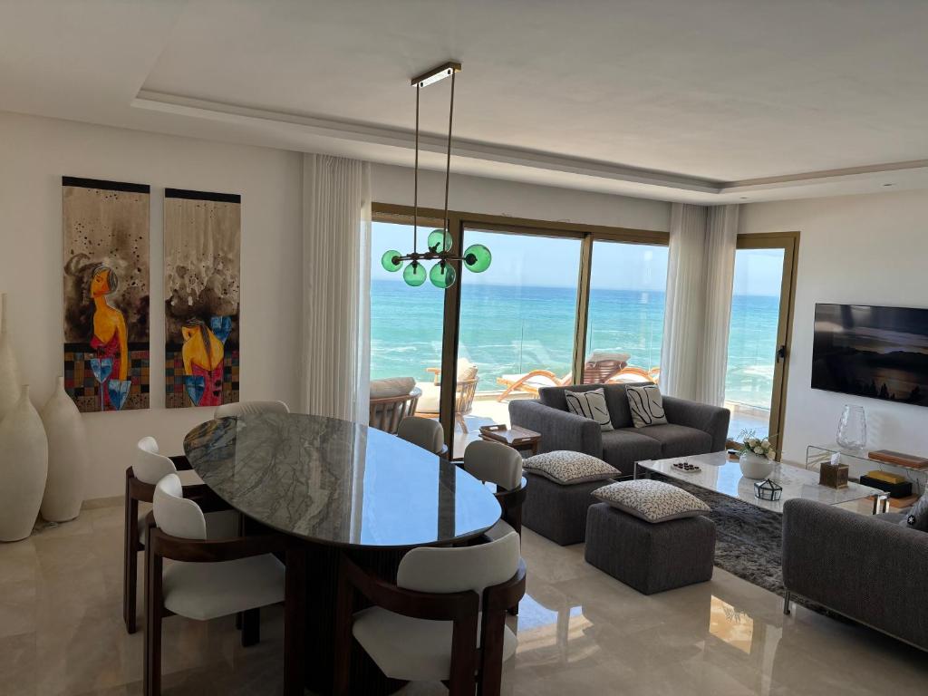 a living room with a table and a view of the ocean at Carrousel Atlantic View in Rabat