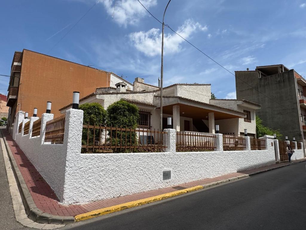 a white fence in front of a house at El refugio de NaRo in Chella