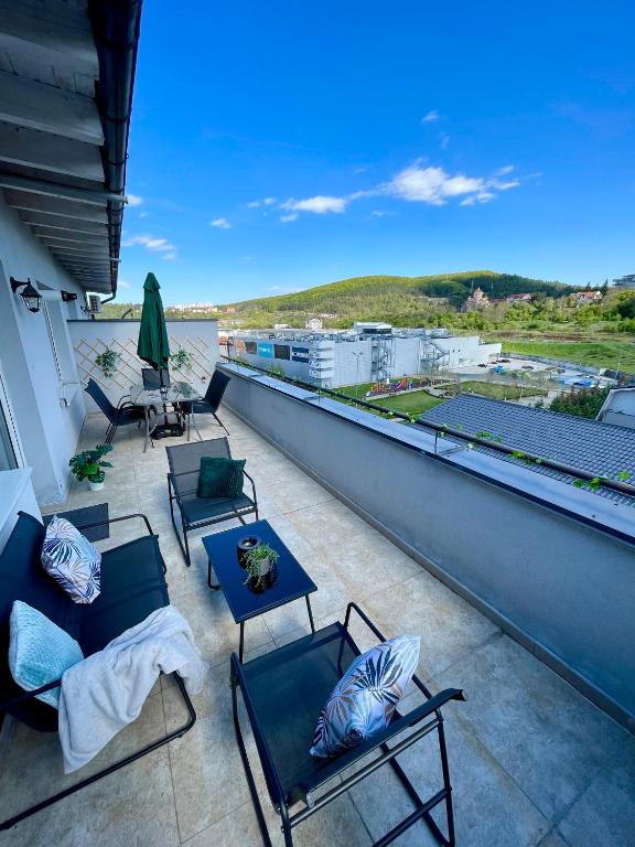 a balcony with chairs and tables on a roof at Sunny View 2BR Apartment with Terrace - near VIVO and Amethyst in Floreşti