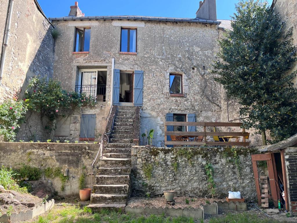 an old stone house with stairs in front of it at Le Grain d Or in Blois